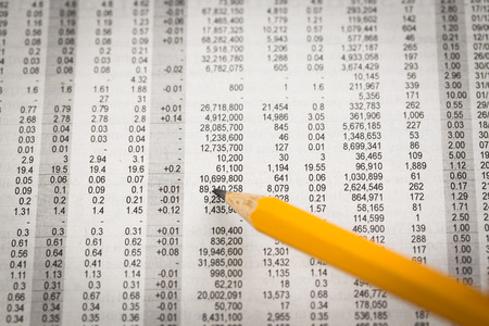 Pencil resting on world currency figuresの写真素材