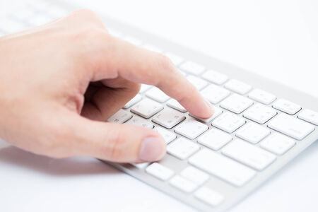 Close-up of man hand typing on keyboardの写真素材