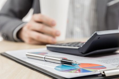 Businessman's hand showing financial report on tableの写真素材