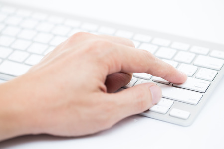 Close-up of man hand typing on keyboardの写真素材