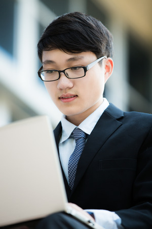 young businessman working outside with laptopの写真素材