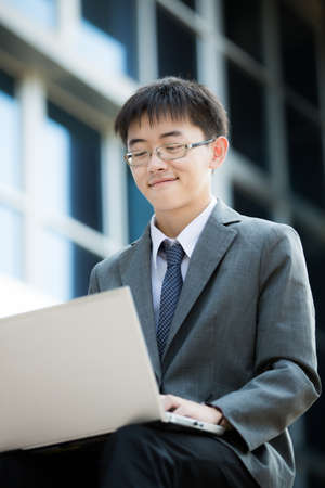 young businessman working outside with laptopの写真素材