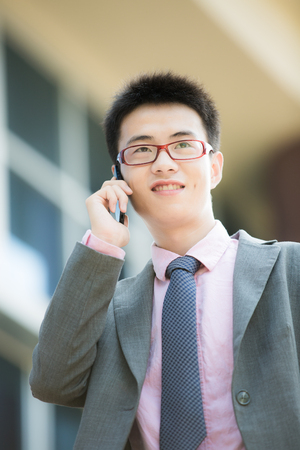 young businessman using cellphone closeup portraitの写真素材
