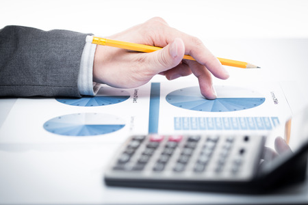 Businessman's hand showing financial report on tableの写真素材