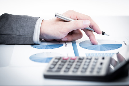 Businessman's hand showing financial report on tableの写真素材