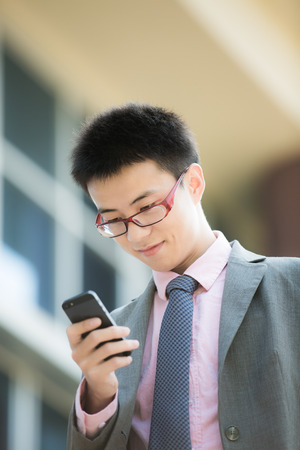 young businessman using cellphone closeup portraitの写真素材