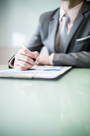business report and man hand with pen. Accountingの写真素材