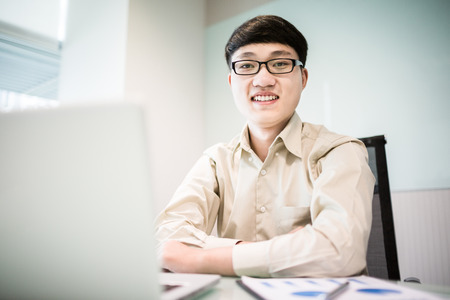 Young handsome man using laptop in his office.Asianの写真素材