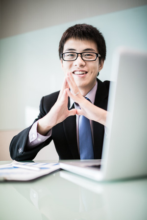 Young handsome man using laptop in his office.Asianの写真素材