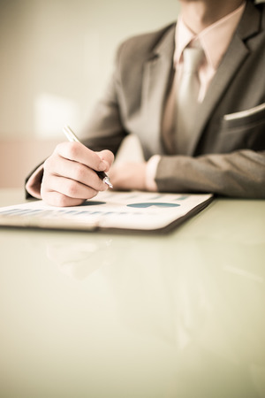 business report and man hand with pen. Accountingの写真素材
