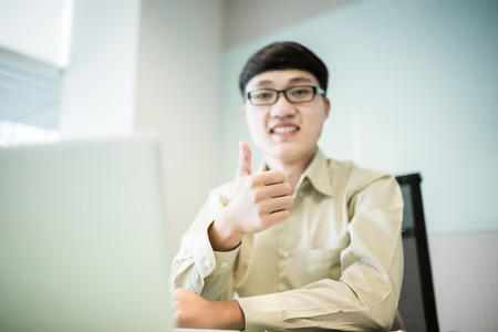 Young handsome man using laptop in his office.Asianの写真素材