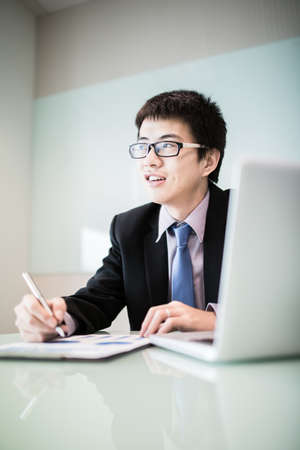 Young handsome man using laptop in his office.Asianの写真素材