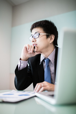 Young handsome man using laptop in his office.Asianの写真素材