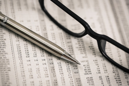 closeup glasses on financial newspaper with pen.Accountingの写真素材