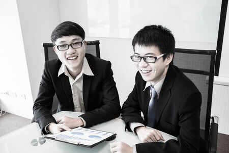 Two managers discussing contract in meeting room.Asianの写真素材