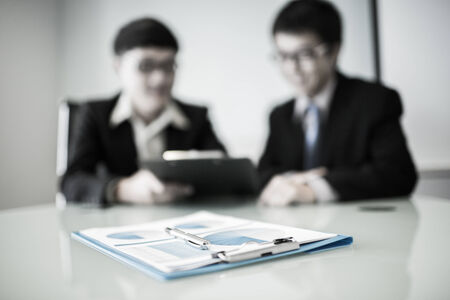 Two managers discussing contract in meeting room.Asianの写真素材