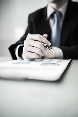 business report and man hand with pen. Accountingの写真素材