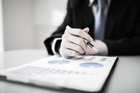 business report and man hand with pen. Accountingの写真素材