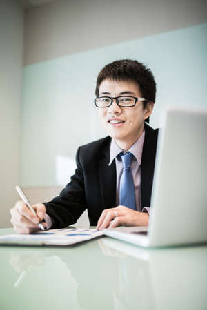 Young handsome man using laptop in his office.Asianの写真素材