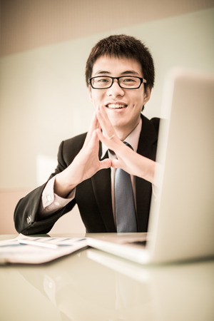 Young handsome man using laptop in his office.Asianの写真素材