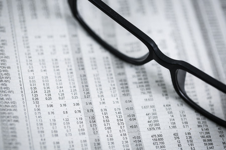 closeup glasses on financial newspaper with pen.Accountingの写真素材