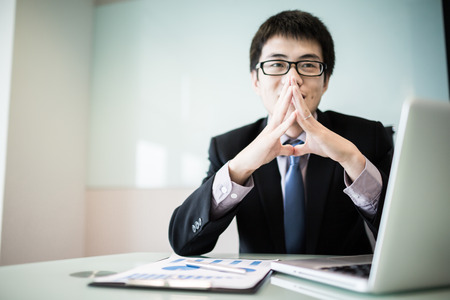 Young handsome man using laptop in his office.Asianの写真素材