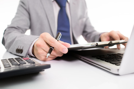 Businessman analyzing investment charts with laptop. の写真素材