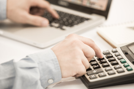 Businessman analyzing investment charts with laptop. の写真素材