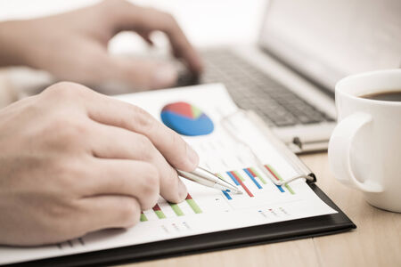 Businessman analyzing investment charts with laptop. の写真素材