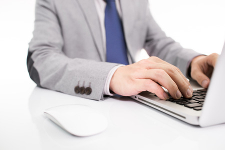 Hands of a man working with laptop on tableの写真素材