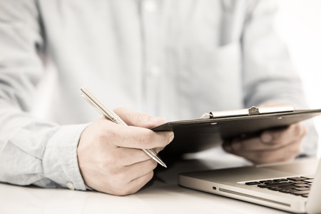 Businessman analyzing investment charts with laptop. の写真素材