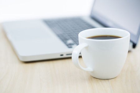 Hands of a man working with laptop and cup of coffeeの写真素材