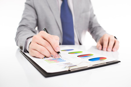 Businessman analyzing investment charts with laptop. の写真素材