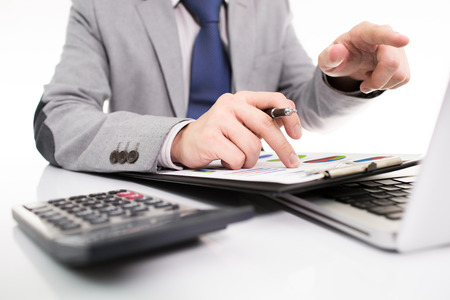 Businessman analyzing investment charts with laptop. の写真素材