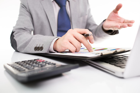 Businessman analyzing investment charts with laptop. の写真素材