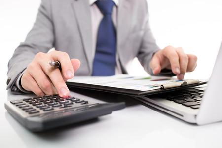 Businessman analyzing investment charts with laptop. の写真素材