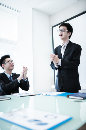 Businessman standing in front of colleagues during a meeting.Asianの写真素材