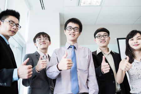 Business team holding their thumbs up.Asianの写真素材