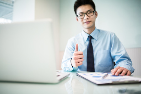 Young handsome man using laptop in his office.Asianの写真素材