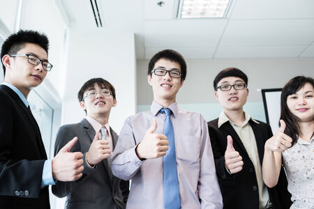 Business team holding their thumbs up.Asianの写真素材