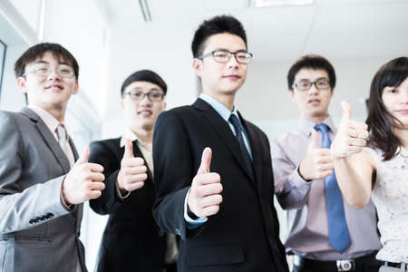 Business team holding their thumbs up.Asianの写真素材
