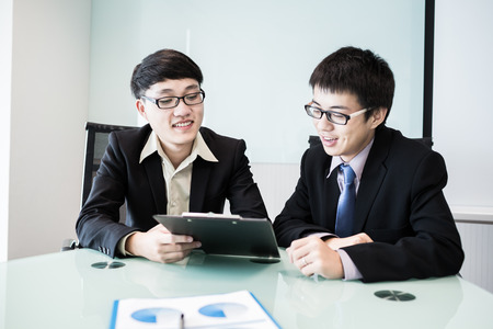 Two managers discussing contract in meeting room.Asianの写真素材