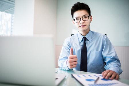 Young handsome man using laptop in his office.Asianの写真素材