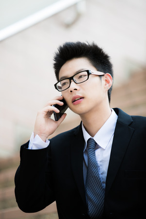 young businessman using cellphone closeup portraitの写真素材