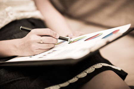 Beautiful woman working at home with report on bedの写真素材