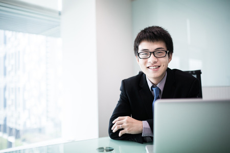Young handsome man using laptop in his office.Asianの写真素材
