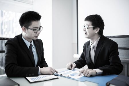 Two Businessmen Having Informal Meeting In Modern Office.Asianの写真素材