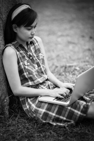 Beautiful young woman using laptop at outdoorの写真素材