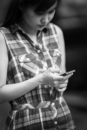 Woman using mobile smart phone in the park.の写真素材