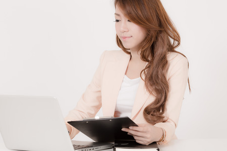 Portrait of a young business woman using laptop at officeの写真素材